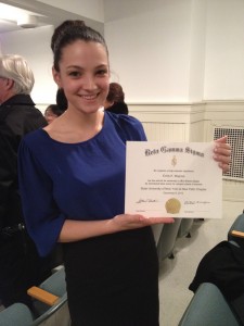 Emily holding her membership certificate after being inducted into the Beta Gamma Sigma Honor Society, exclusive to business students at an AACSB accredited school who rank in the top 10 percent of their graduating class