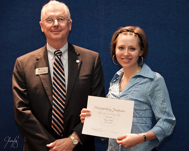 Olga receiving the Outstanding Graduate Award with President Donald P. Christian