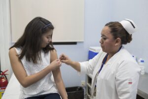 Nurse administers vaccine to female patient